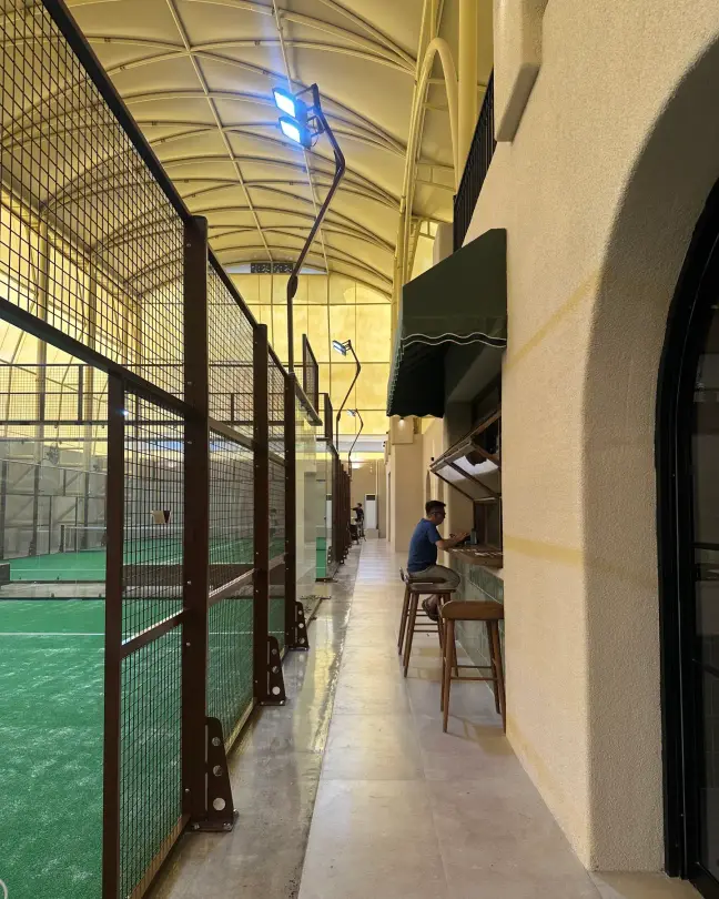 Courtside walkway with bar stools along the glass