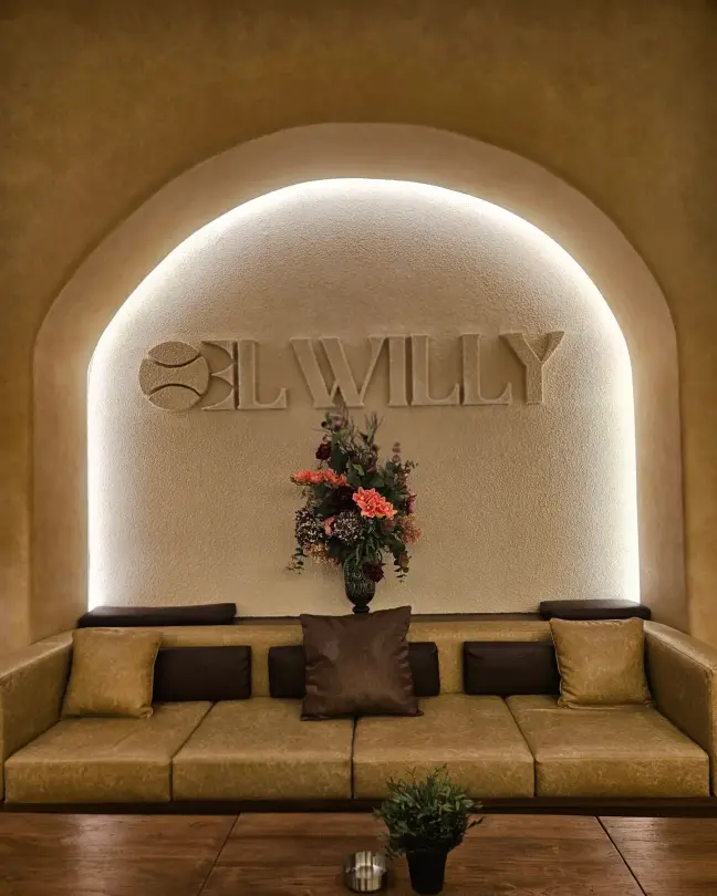 Lit niche with the El Willy wordmark above a sofa
